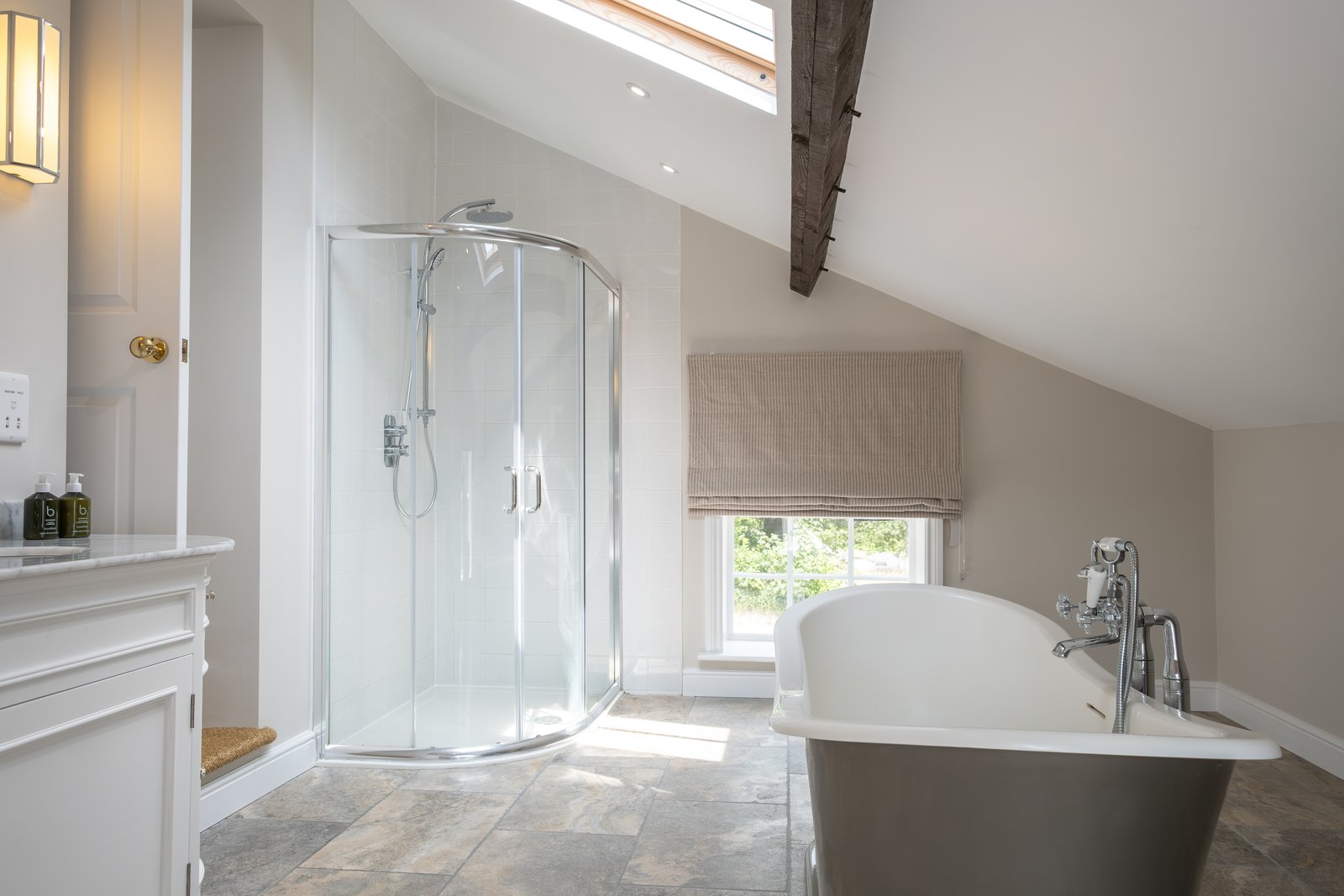 The principal bathroom, with a quadrant shower and a slipper bath beneath the eaves