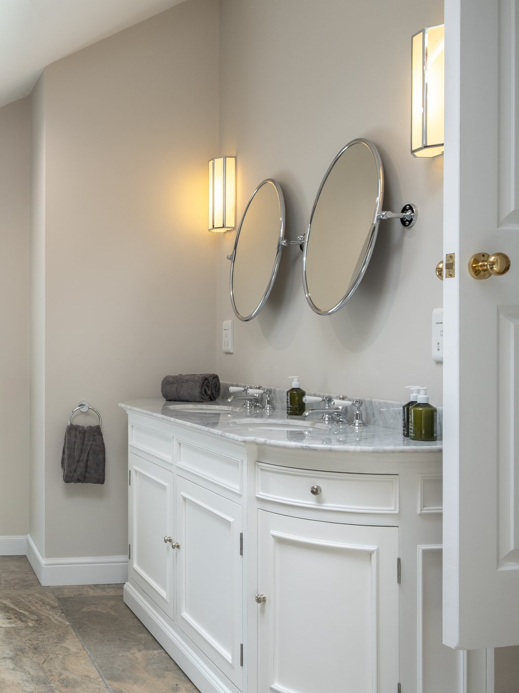 The principal en suite, with twin oval mirrors above a marble vanity