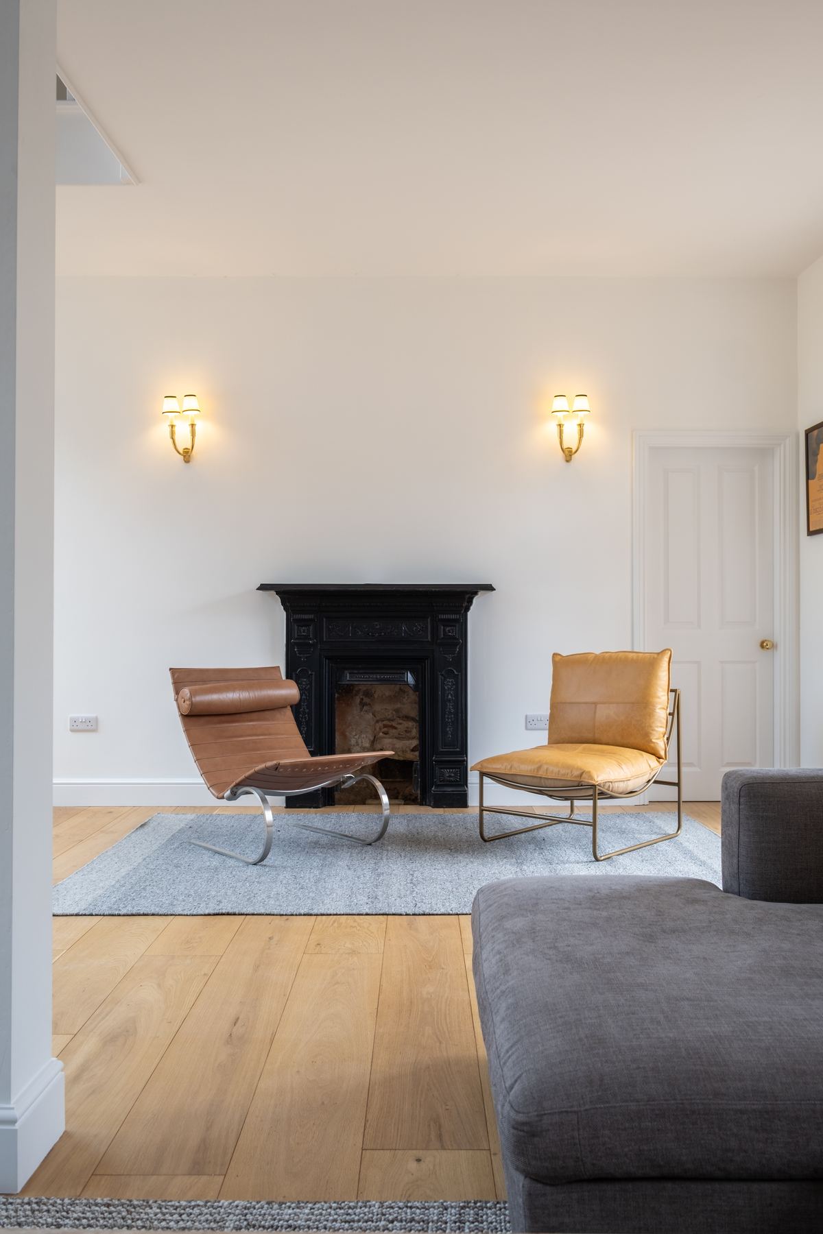 The sitting room, with a black cast-iron fireplace and mid-century leather chairs