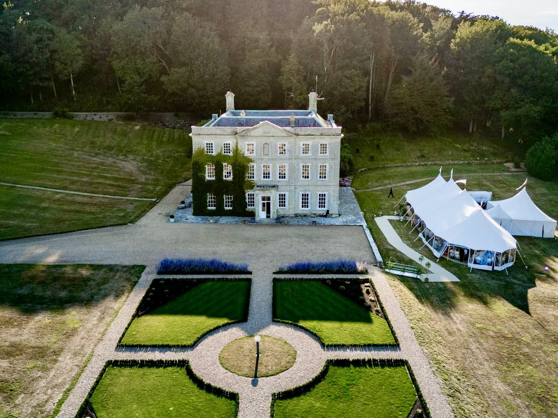 The house and its parterre from above, with a marquee on the lawn beside it