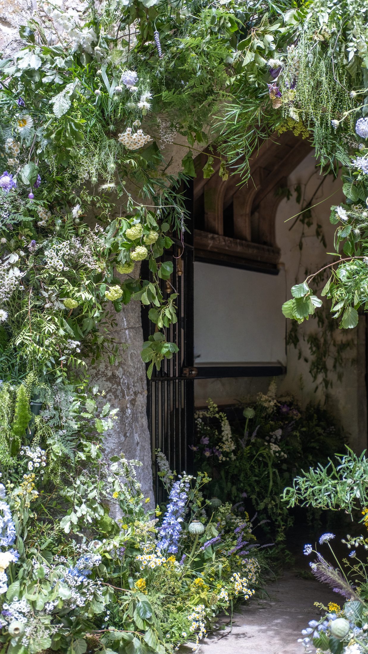 The south door framed with climbing flowers and greenery
