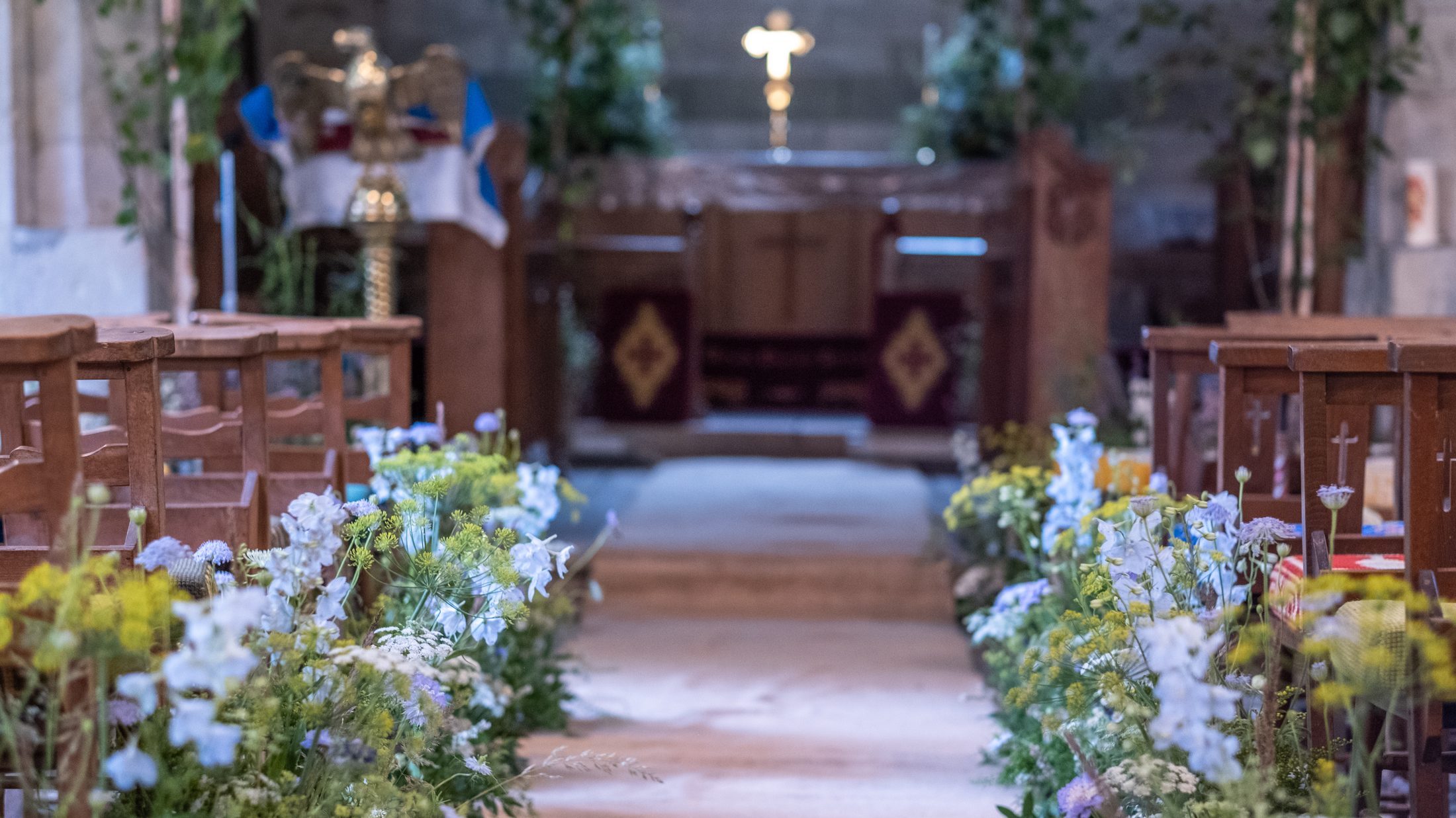 The nave of St Olave's, the pews dressed with blue and white flowers